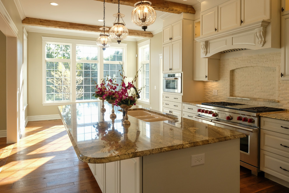 Eat-in kitchen - large traditional galley painted wood floor eat-in kitchen idea in Other with a triple-bowl sink, raised-panel cabinets, white cabinets, granite countertops, white backsplash, brick backsplash, stainless steel appliances and an island