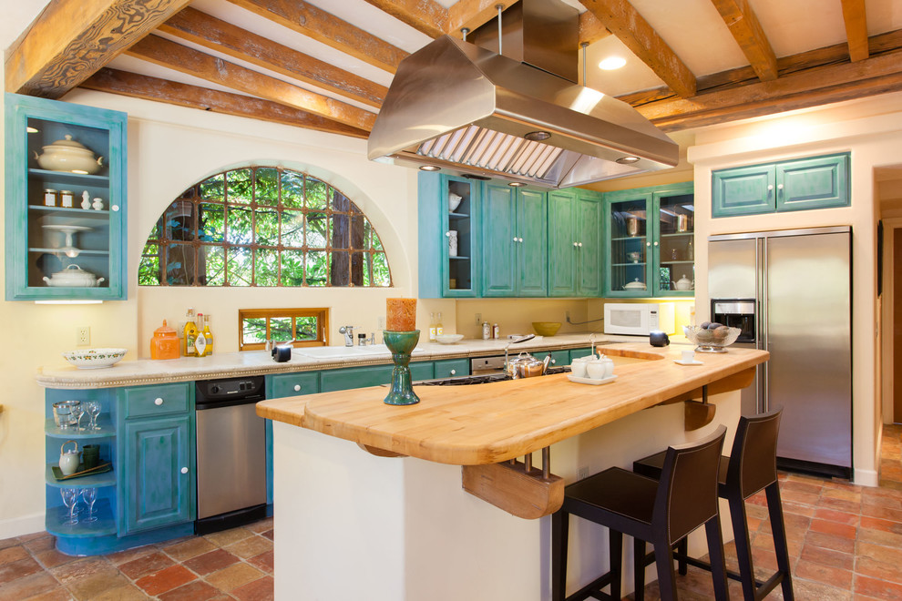 Example of a southwest l-shaped kitchen design in San Francisco with a drop-in sink, raised-panel cabinets, wood countertops, stainless steel appliances and turquoise cabinets