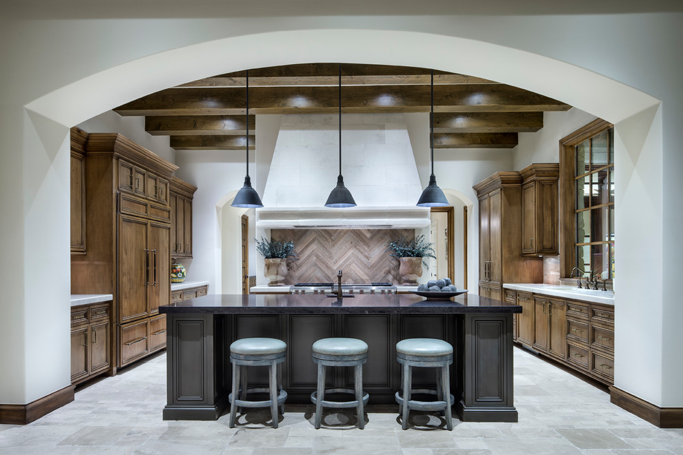 This is an example of a large mediterranean galley kitchen/diner in Austin with recessed-panel cabinets and an island.
