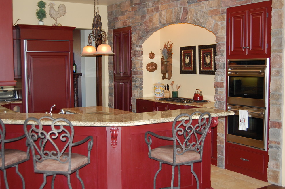 Cette photo montre une cuisine méditerranéenne avec des portes de placard rouges.