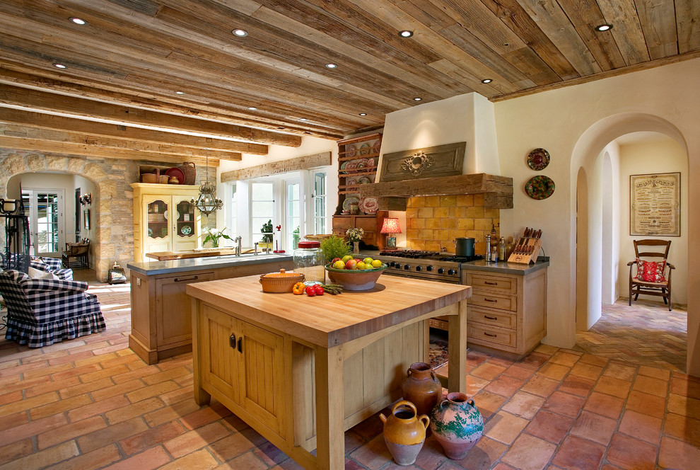 Inspiration for a huge french country terra-cotta tile open concept kitchen remodel in Santa Barbara with shaker cabinets, medium tone wood cabinets and wood countertops
