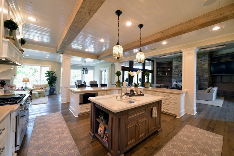 Open concept kitchen - mid-sized traditional u-shaped medium tone wood floor and brown floor open concept kitchen idea in Other with a farmhouse sink, recessed-panel cabinets, white cabinets, marble countertops, gray backsplash, stainless steel appliances and an island