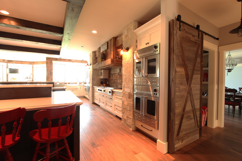 Idéer för att renovera ett stort lantligt vit vitt kök, med en rustik diskho, luckor med infälld panel, skåp i mörkt trä, bänkskiva i kvarts, flerfärgad stänkskydd, stänkskydd i sten, integrerade vitvaror, mellanmörkt trägolv, flera köksöar och brunt golv
