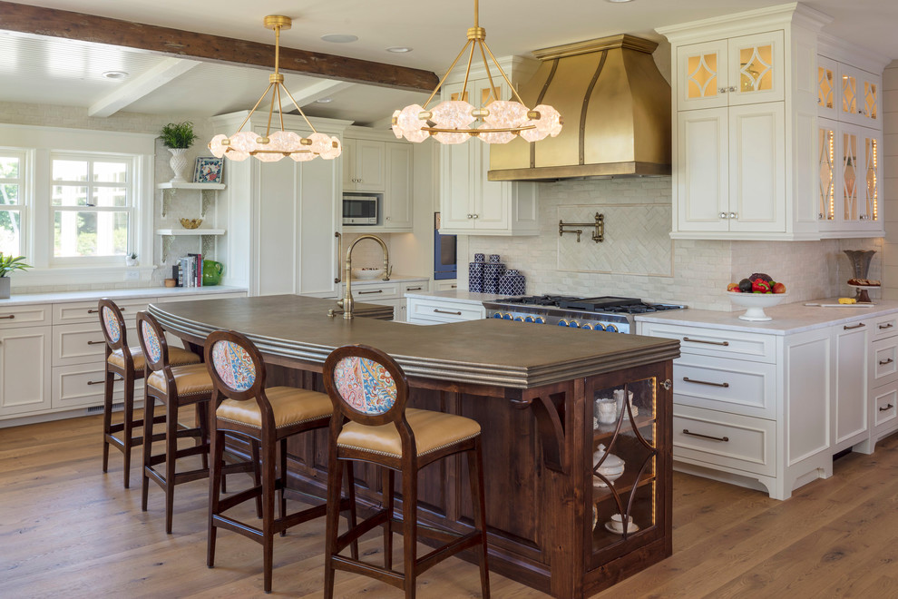Klassische Küche mit Schrankfronten mit vertiefter Füllung, weißen Schränken, Küchenrückwand in Weiß, braunem Holzboden und Kücheninsel in Minneapolis