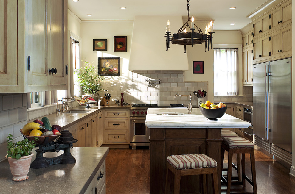 Cette photo montre une cuisine en U avec un électroménager en acier inoxydable et des portes de placard beiges.