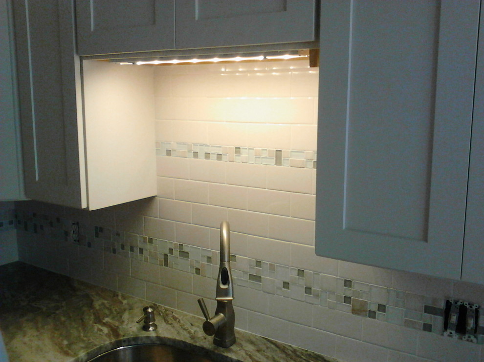 Immagine di una cucina abitabile stile americano con ante in stile shaker, ante bianche, top in granito, paraspruzzi bianco, paraspruzzi con piastrelle diamantate e elettrodomestici in acciaio inossidabile