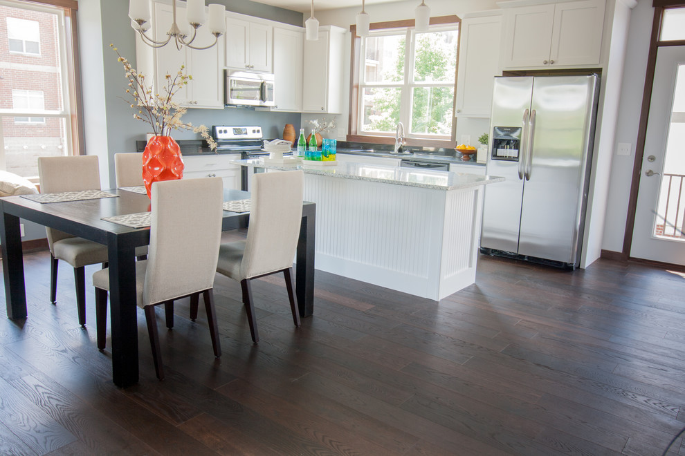 Inspiration for a mid-sized mediterranean dark wood floor and brown floor open concept kitchen remodel in Minneapolis with a drop-in sink, white cabinets, quartzite countertops, stainless steel appliances, an island and shaker cabinets