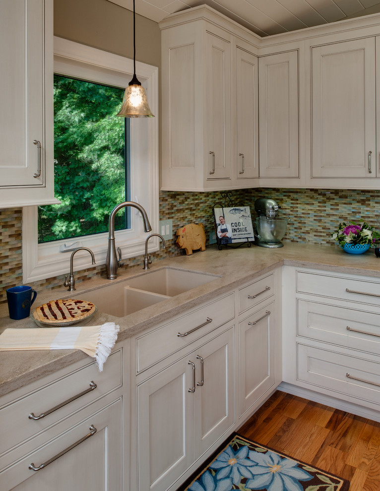 Inspiration for a mid-sized timeless l-shaped medium tone wood floor eat-in kitchen remodel in Other with an integrated sink, recessed-panel cabinets, gray cabinets, solid surface countertops, multicolored backsplash, glass sheet backsplash, stainless steel appliances and an island