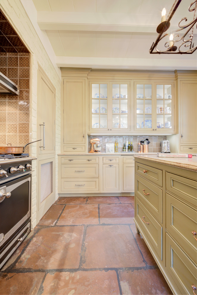 Immagine di una piccola cucina classica chiusa con ante a filo, ante con finitura invecchiata, elettrodomestici da incasso e pavimento in terracotta