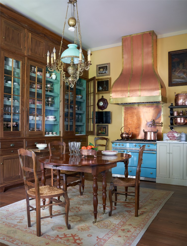 Diseño de cocina comedor tradicional con armarios con paneles empotrados, puertas de armario grises, electrodomésticos de colores, suelo de madera oscura y suelo marrón