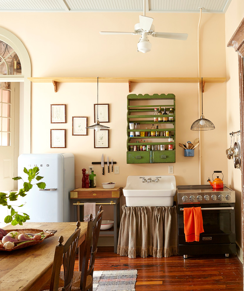 Example of a small eclectic single-wall dark wood floor eat-in kitchen design in New Orleans with a farmhouse sink