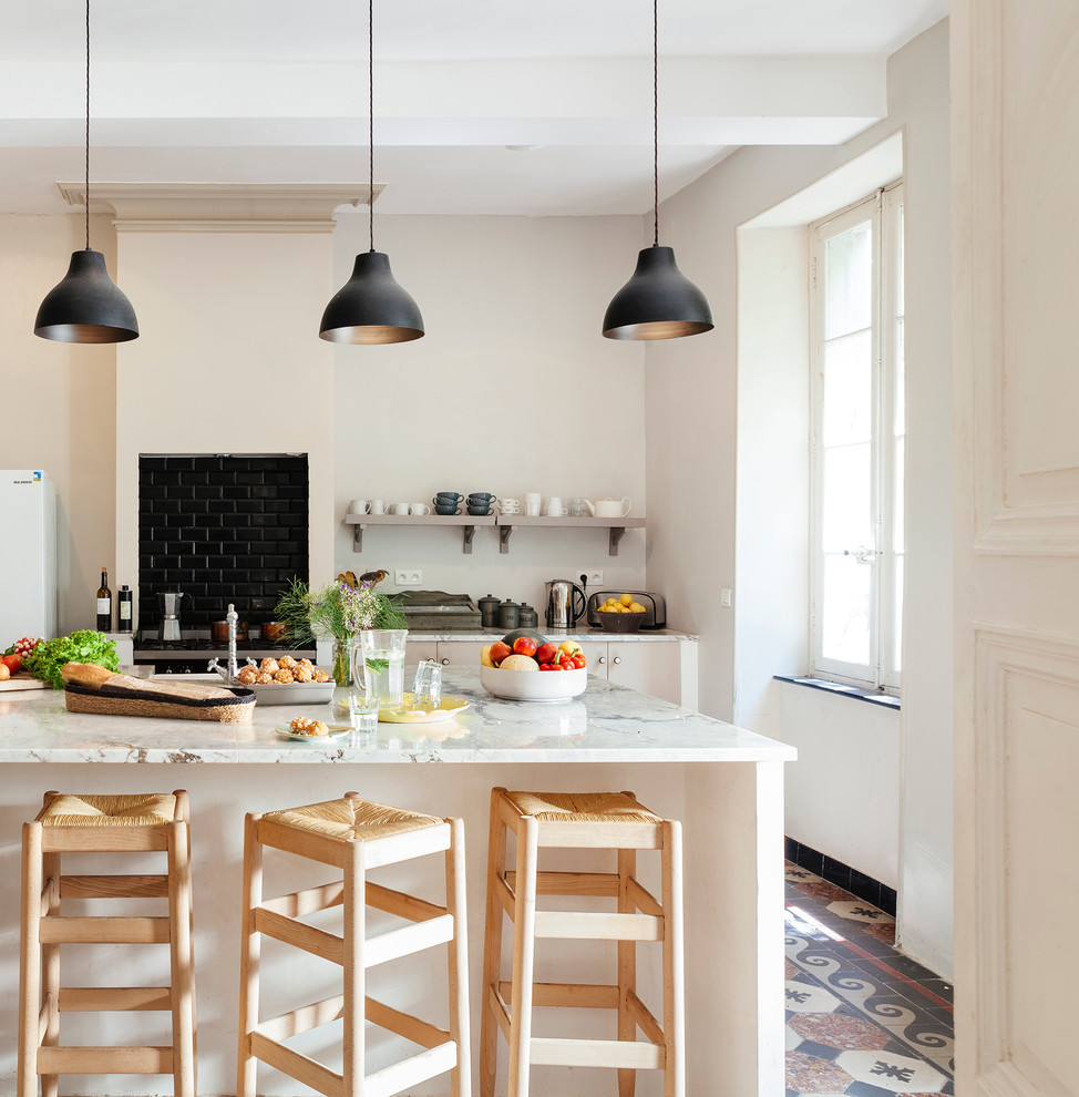 Zweizeilige, Mittelgroße Mediterrane Wohnküche mit offenen Schränken, Küchenrückwand in Schwarz, Rückwand aus Metrofliesen, Kücheninsel und Marmor-Arbeitsplatte in Toulouse