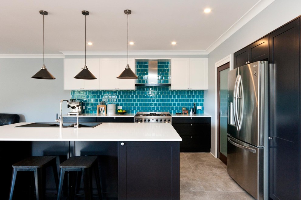 This is an example of a medium sized modern l-shaped open plan kitchen in Sydney with a double-bowl sink, shaker cabinets, black cabinets, engineered stone countertops, metro tiled splashback, stainless steel appliances, an island, beige floors, white worktops, blue splashback and porcelain flooring.