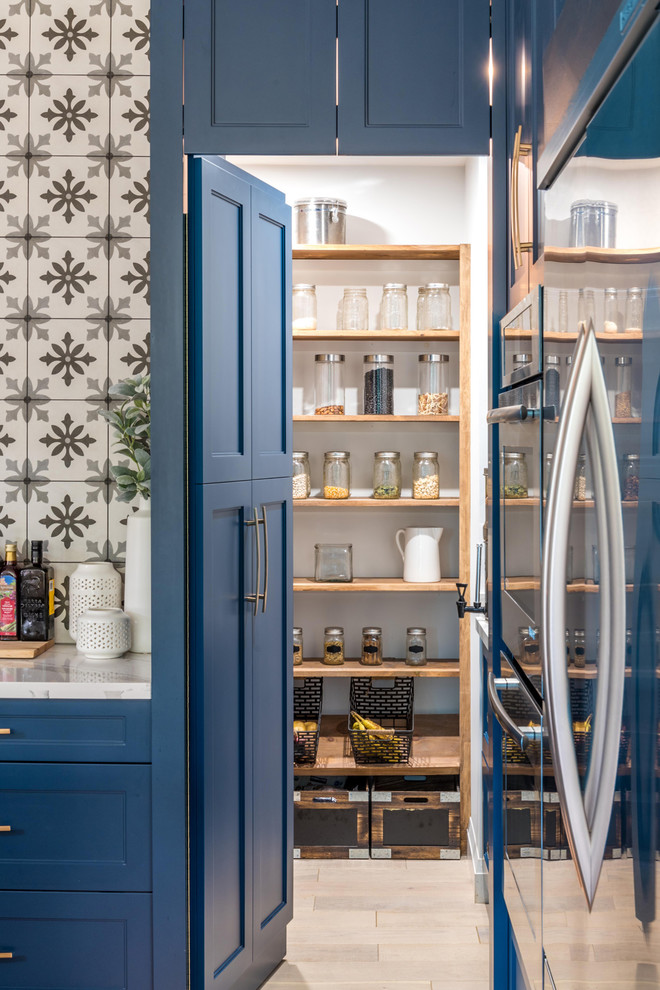 Inspiration pour une arrière-cuisine traditionnelle avec des portes de placard bleues, un sol beige et parquet clair.