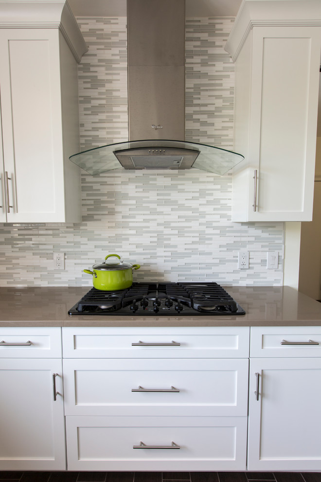 This is an example of an expansive contemporary l-shaped open plan kitchen in Bridgeport with a submerged sink, shaker cabinets, white cabinets, engineered stone countertops, white splashback, mosaic tiled splashback, stainless steel appliances, porcelain flooring and an island.