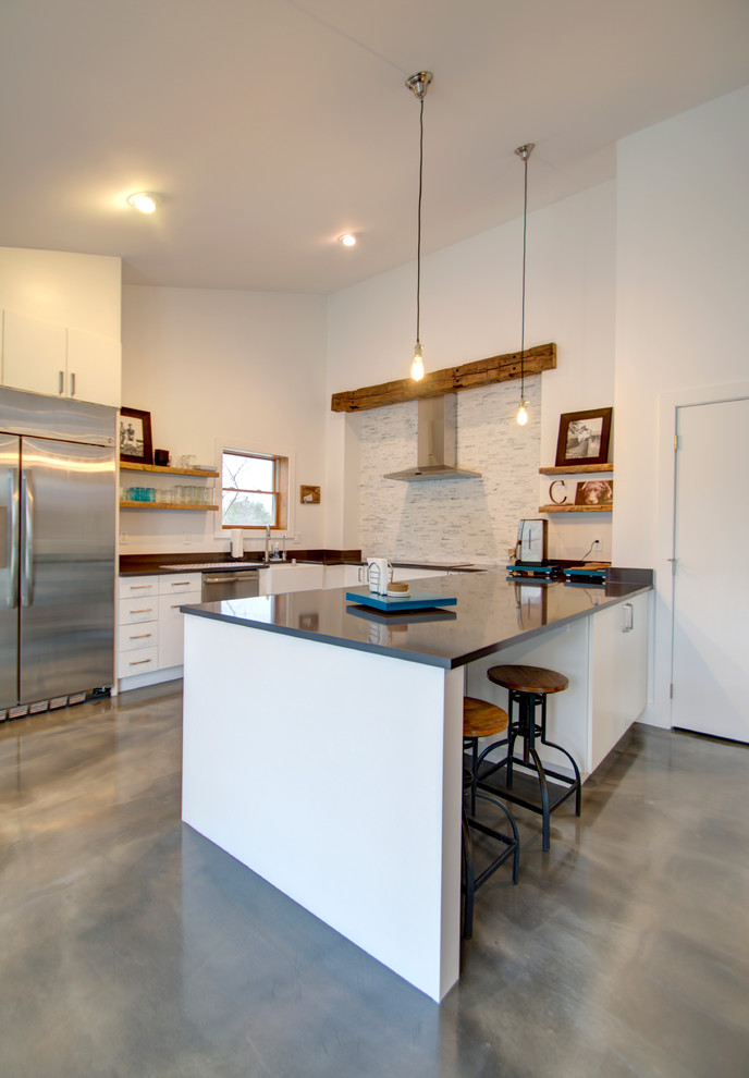 Modern inredning av ett mellanstort kök, med en rustik diskho, släta luckor, vita skåp, bänkskiva i kvarts, vitt stänkskydd, stänkskydd i stenkakel, rostfria vitvaror och betonggolv