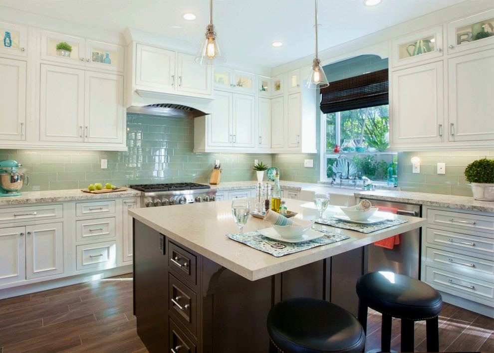 Inspiration for a mid-sized coastal medium tone wood floor kitchen remodel in Los Angeles with an island, shaker cabinets, dark wood cabinets, green backsplash, ceramic backsplash, stainless steel appliances, a farmhouse sink and granite countertops