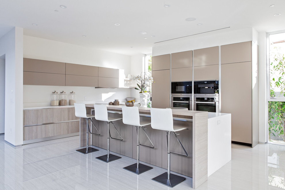 Design ideas for a small modern l-shaped open plan kitchen in Los Angeles with flat-panel cabinets, beige cabinets, engineered stone countertops, white splashback, stainless steel appliances, porcelain flooring and an island.