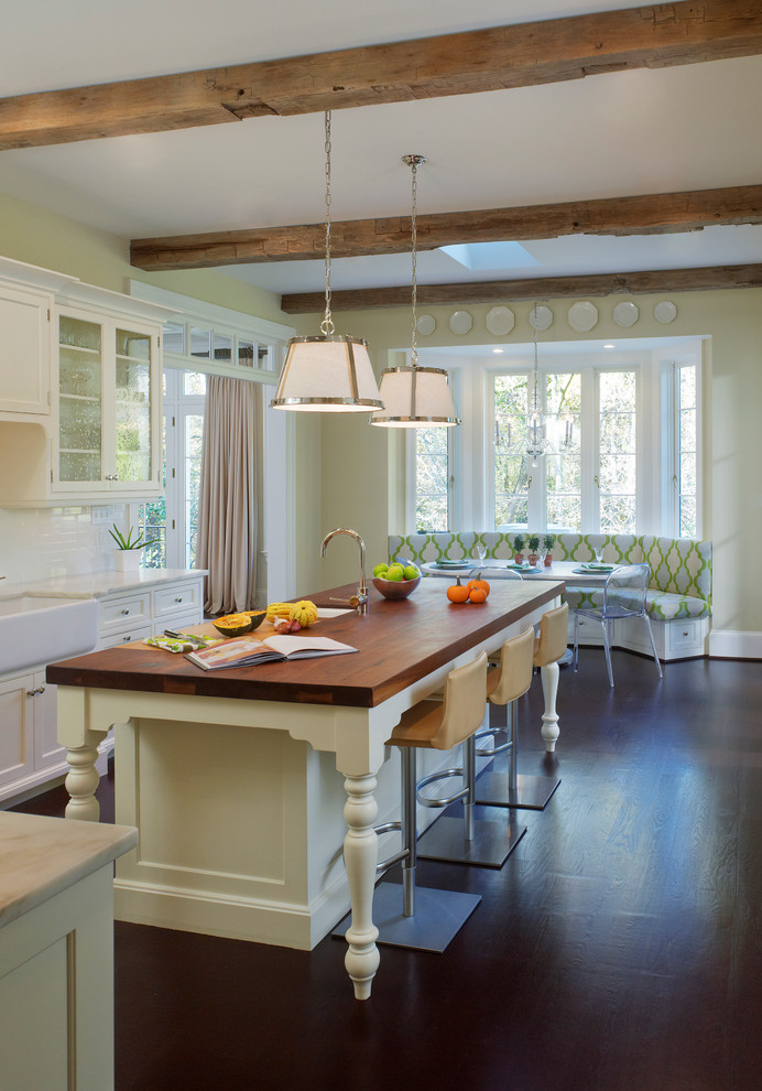 Ejemplo de cocina clásica con fregadero sobremueble, encimera de madera, armarios tipo vitrina, salpicadero blanco y salpicadero de azulejos tipo metro