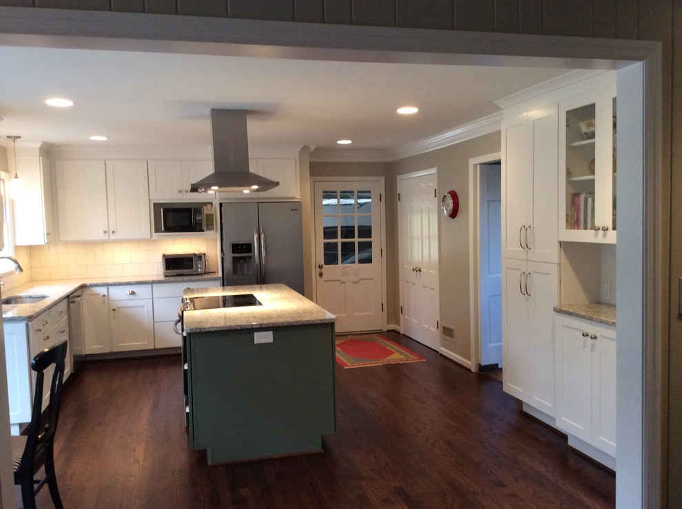 Eat-in kitchen - mid-sized traditional l-shaped medium tone wood floor eat-in kitchen idea in Birmingham with an undermount sink, recessed-panel cabinets, white cabinets, granite countertops, white backsplash, ceramic backsplash and stainless steel appliances
