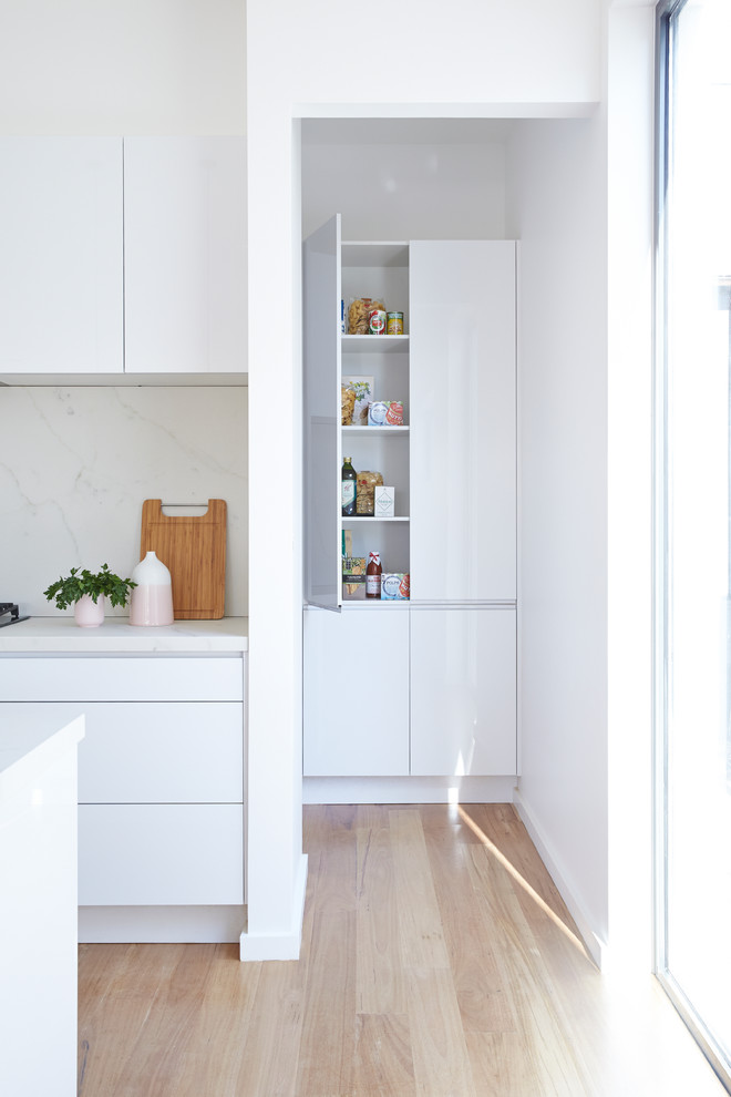 Zweizeilige Moderne Küche mit Vorratsschrank, weißen Schränken, Marmor-Arbeitsplatte, Küchenrückwand in Weiß, Rückwand aus Stein und Kücheninsel in Sydney
