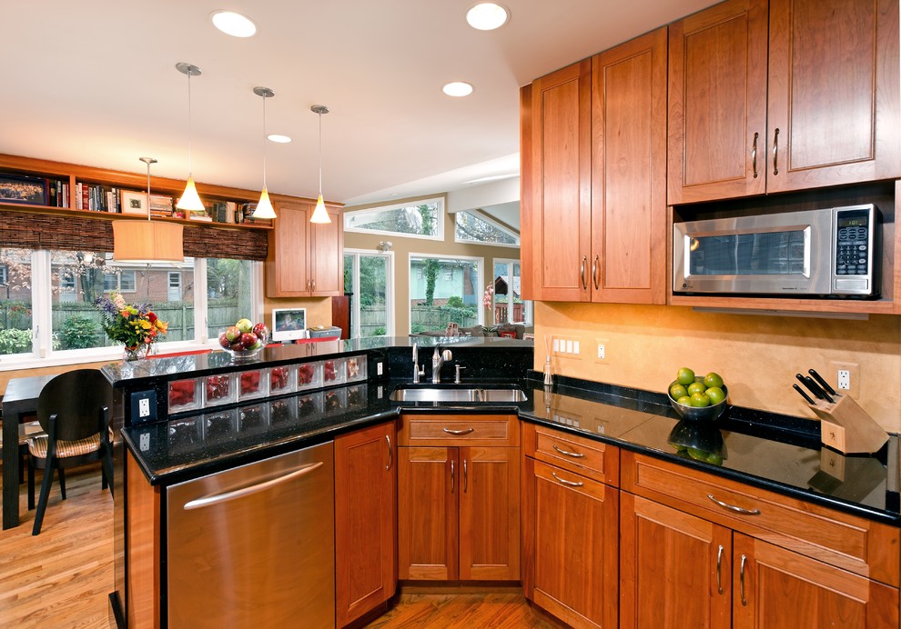 Elegant u-shaped medium tone wood floor eat-in kitchen photo in DC Metro with a double-bowl sink, shaker cabinets, medium tone wood cabinets, granite countertops and stainless steel appliances