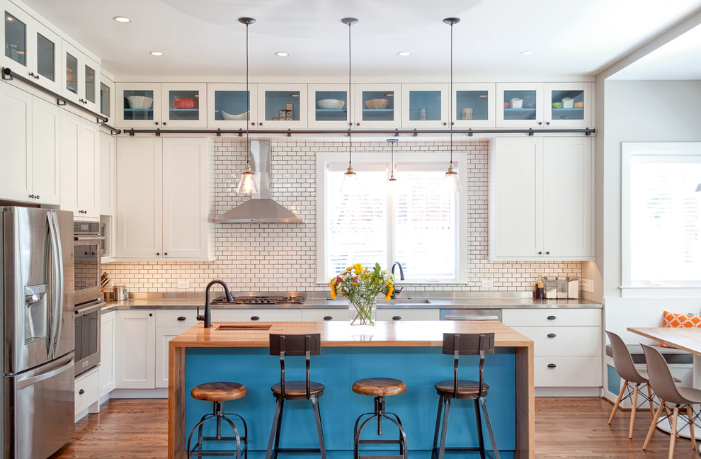 Transitional medium tone wood floor eat-in kitchen photo in DC Metro with a single-bowl sink, shaker cabinets, white cabinets, white backsplash, subway tile backsplash, stainless steel appliances, an island and wood countertops