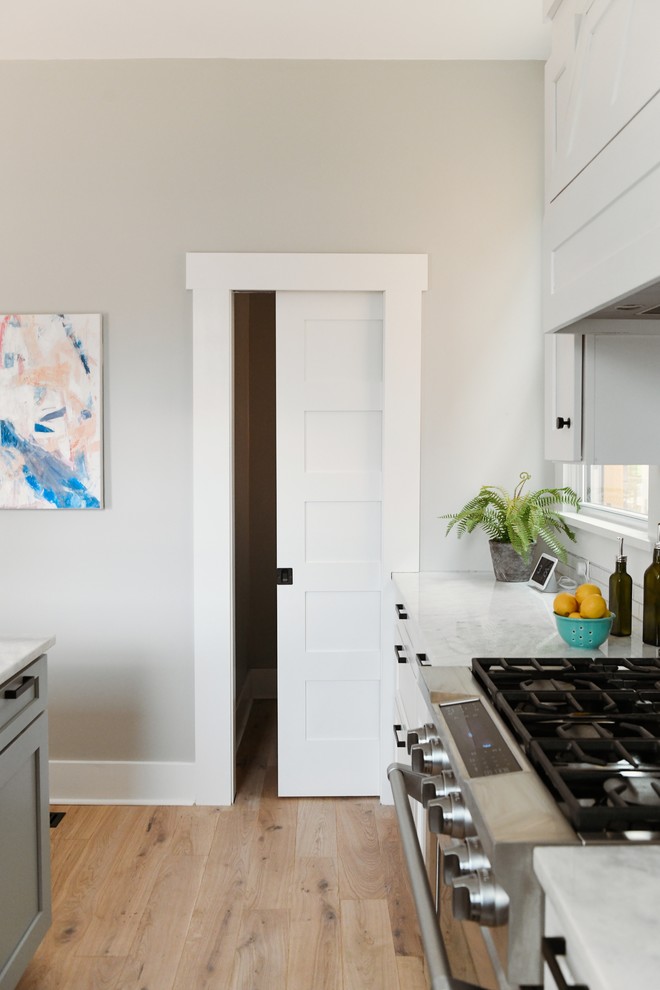 Imagen de cocina actual de tamaño medio con armarios estilo shaker, puertas de armario blancas, encimera de cuarcita, una isla y encimeras blancas