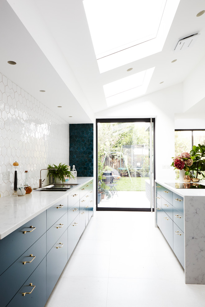 Inspiration for a modern ceramic tile and gray floor open concept kitchen remodel in London with an integrated sink, flat-panel cabinets, turquoise cabinets, marble countertops, white backsplash, ceramic backsplash, an island and white countertops