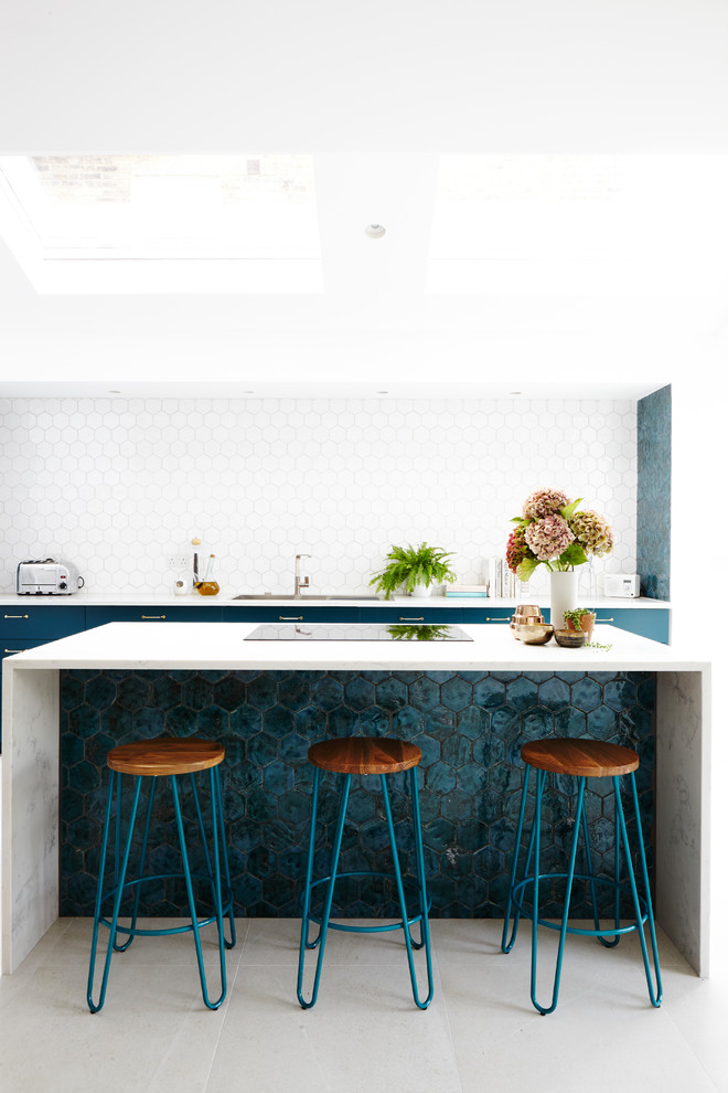 Modern inredning av ett vit vitt kök med öppen planlösning, med släta luckor, turkosa skåp, marmorbänkskiva, vitt stänkskydd, stänkskydd i keramik, en köksö, en integrerad diskho, klinkergolv i keramik och grått golv