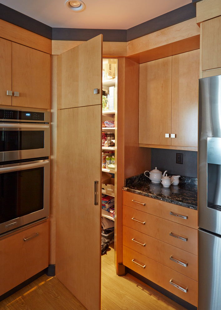 Exempel på ett modernt kök, med en undermonterad diskho, släta luckor, skåp i mellenmörkt trä, grått stänkskydd, stänkskydd i sten, rostfria vitvaror och mellanmörkt trägolv