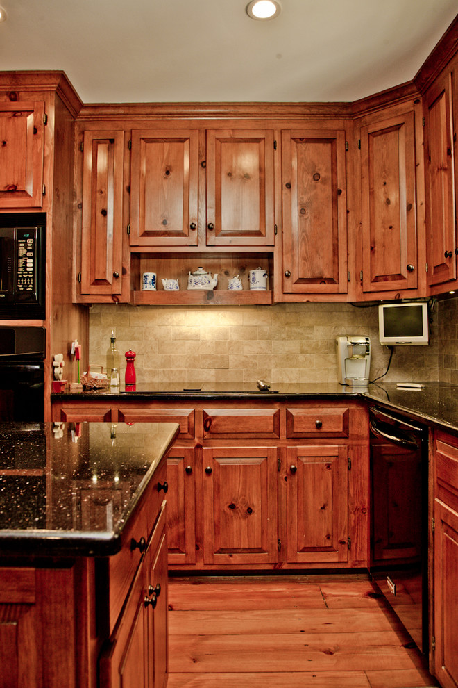 Exempel på ett mellanstort klassiskt kök, med en dubbel diskho, luckor med upphöjd panel, skåp i mellenmörkt trä, bänkskiva i onyx, grått stänkskydd, stänkskydd i keramik, svarta vitvaror och en köksö