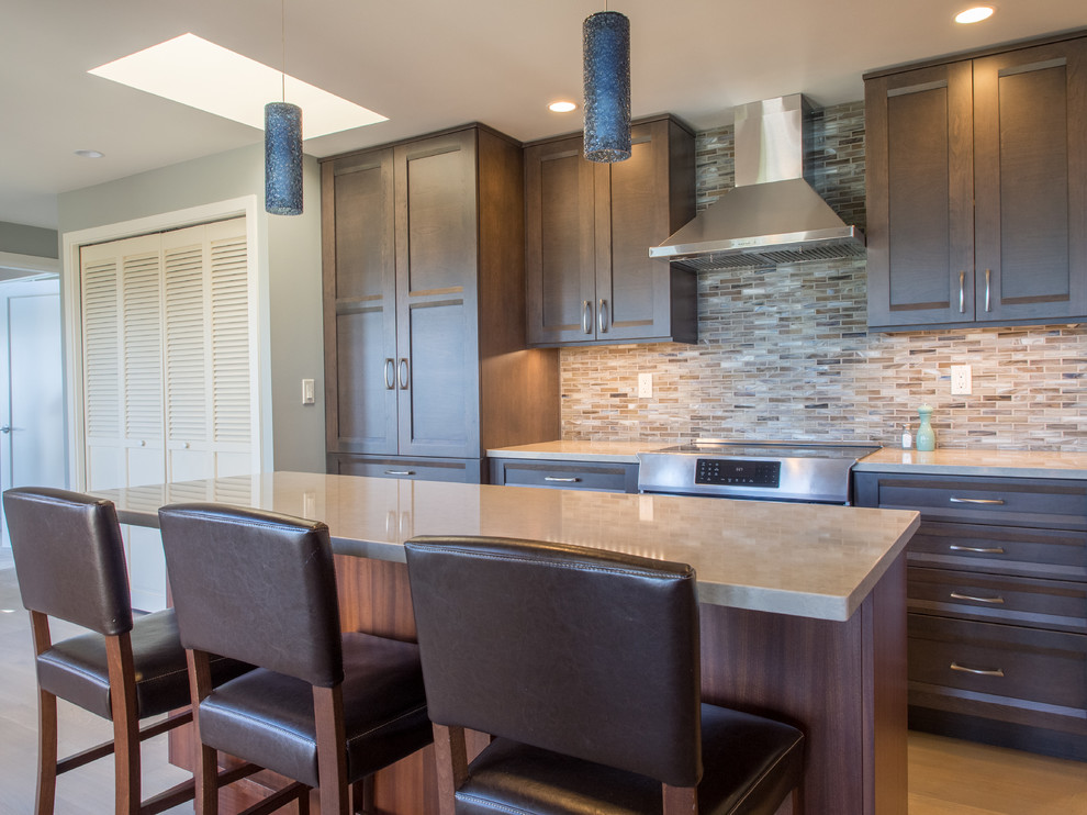 Example of a mid-sized transitional galley medium tone wood floor and gray floor eat-in kitchen design in Seattle with a double-bowl sink, recessed-panel cabinets, dark wood cabinets, quartz countertops, blue backsplash, glass tile backsplash, stainless steel appliances, two islands and blue countertops