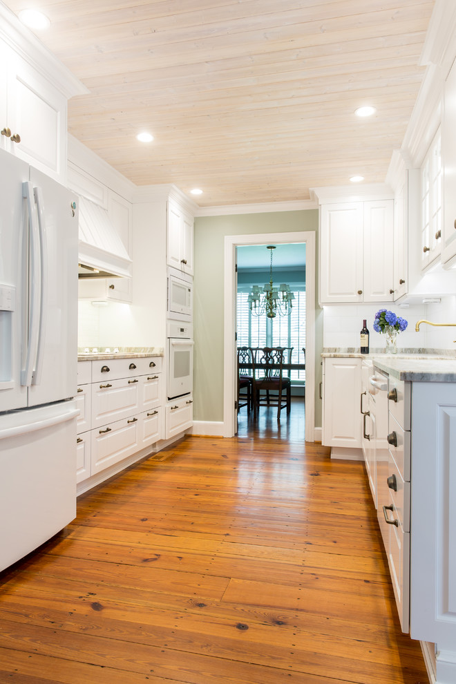 Inspiration for a medium sized classic galley enclosed kitchen in Atlanta with raised-panel cabinets, white cabinets, mosaic tiled splashback, white appliances, light hardwood flooring and no island.