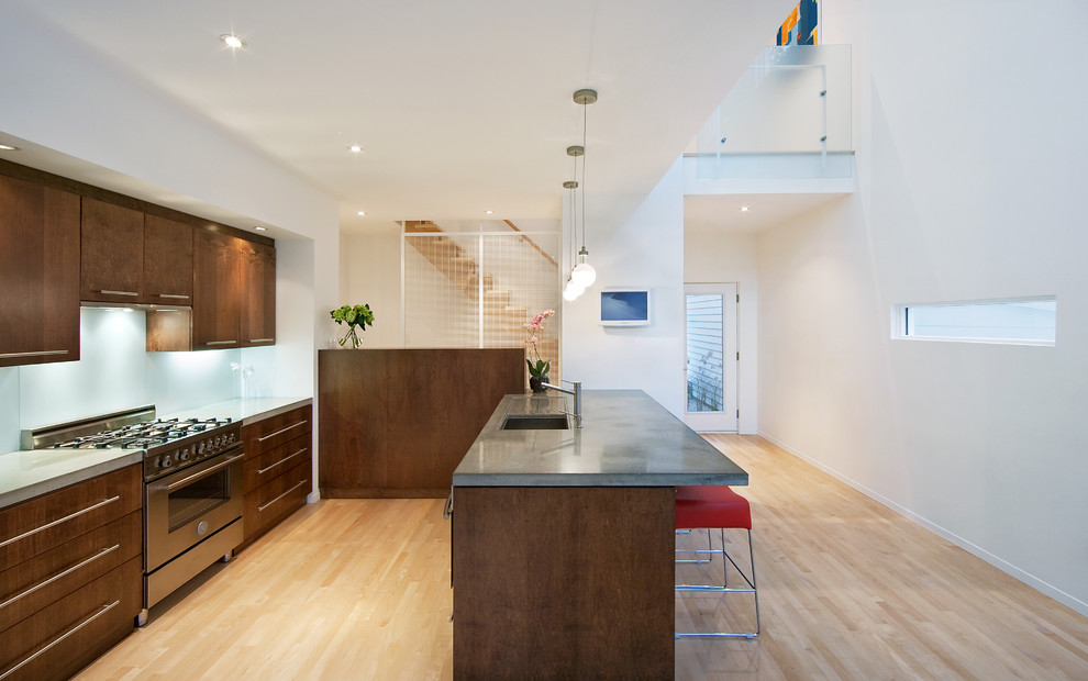 Zweizeilige Moderne Küche mit Unterbauwaschbecken, flächenbündigen Schrankfronten, dunklen Holzschränken, Küchenrückwand in Weiß, Glasrückwand und Küchengeräten aus Edelstahl in Ottawa