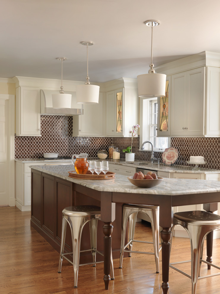 Klassische Küche in L-Form mit Granit-Arbeitsplatte, Küchenrückwand in Braun, braunem Holzboden, Kücheninsel, Schrankfronten im Shaker-Stil und beigen Schränken in St. Louis