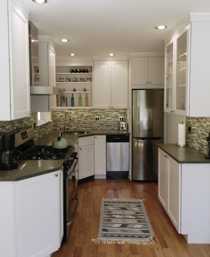 Inspiration for a small traditional u-shaped kitchen in New York with a submerged sink, shaker cabinets, white cabinets, composite countertops, multi-coloured splashback, glass tiled splashback, stainless steel appliances, medium hardwood flooring, no island, brown floors and grey worktops.