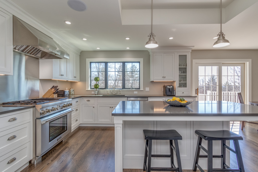 Foto di una cucina chic di medie dimensioni con lavello sottopiano, ante in stile shaker, ante bianche, elettrodomestici in acciaio inossidabile, pavimento marrone e soffitto ribassato