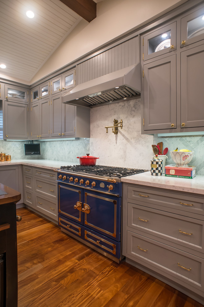 Large eclectic u-shaped medium tone wood floor enclosed kitchen photo in Miami with shaker cabinets, gray cabinets, marble countertops, white backsplash, subway tile backsplash, paneled appliances, an island and a farmhouse sink