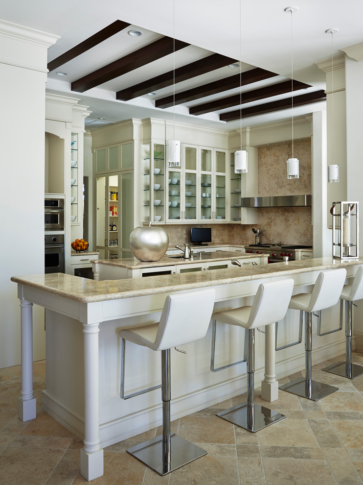 Elegant kitchen photo in Miami with glass-front cabinets, beige cabinets, beige backsplash, stainless steel appliances and an island