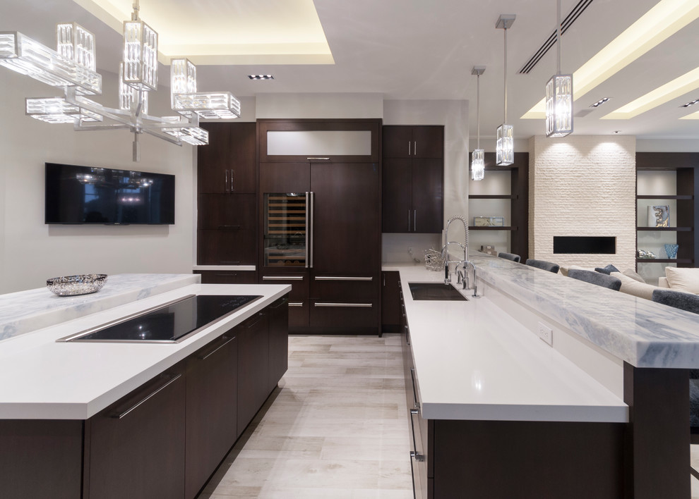 Example of a mid-sized minimalist u-shaped porcelain tile and beige floor eat-in kitchen design in Miami with a drop-in sink, raised-panel cabinets, dark wood cabinets, quartz countertops, white backsplash, paneled appliances and an island