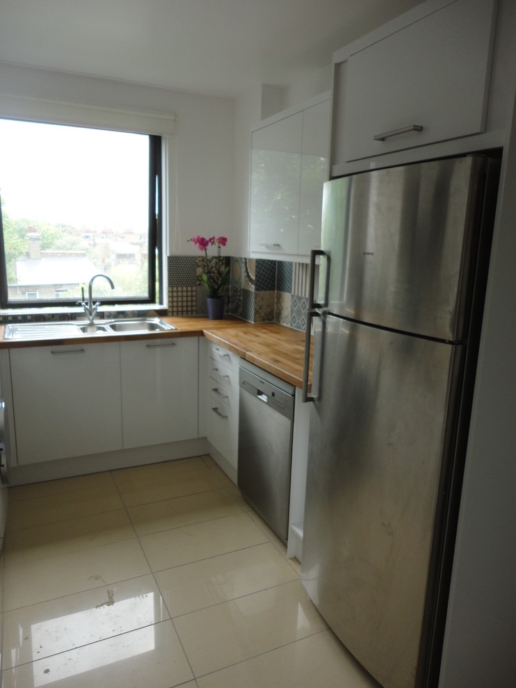 Photo of a small contemporary u-shaped enclosed kitchen in London with no island.