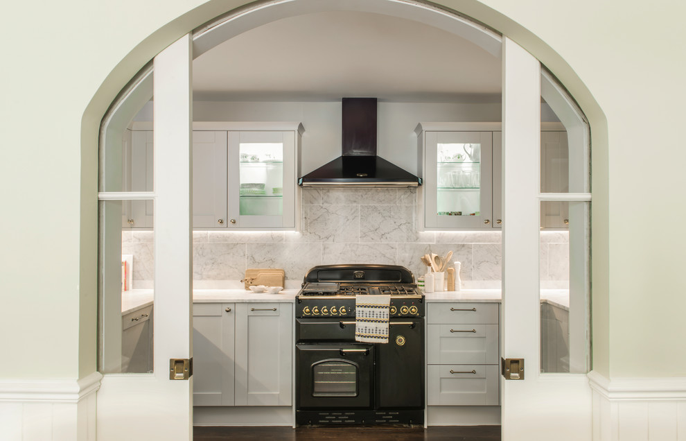 Photo of a classic enclosed kitchen in London with black appliances and no island.