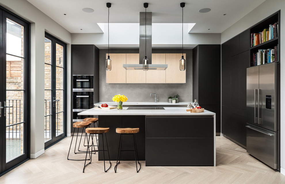 Foto di una cucina minimal con ante lisce, ante nere, parquet chiaro, pavimento beige e top bianco