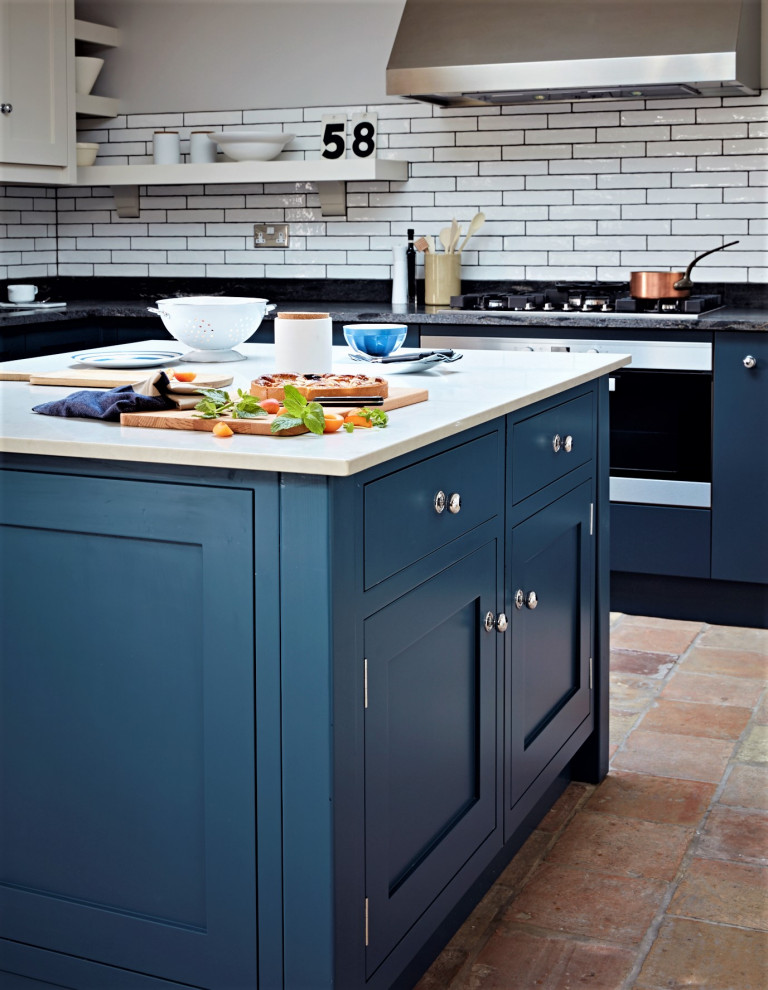 Inspiration pour une cuisine minimaliste en L de taille moyenne avec un placard à porte shaker, des portes de placard bleues, un plan de travail en quartz, îlot et plan de travail noir.