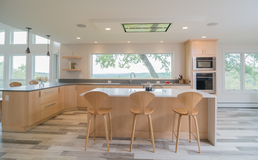 Photo of an expansive contemporary u-shaped open plan kitchen in Boston with a submerged sink, flat-panel cabinets, light wood cabinets, granite worktops, stainless steel appliances, an island and multi-coloured floors.