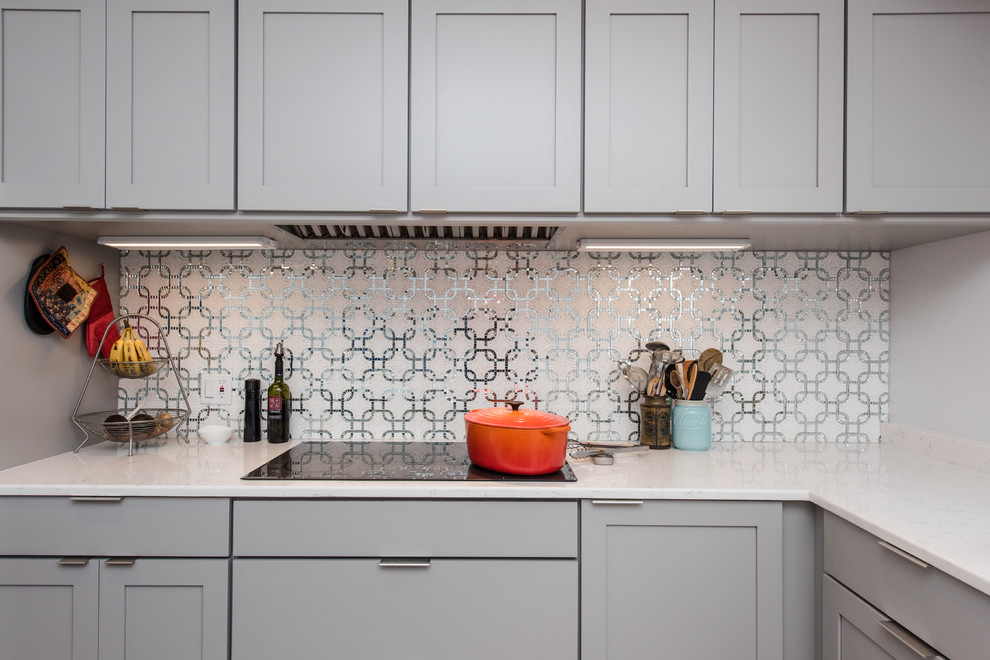 Example of a mid-sized transitional l-shaped porcelain tile eat-in kitchen design in DC Metro with an undermount sink, shaker cabinets, blue cabinets, glass countertops, gray backsplash, mosaic tile backsplash, stainless steel appliances and an island