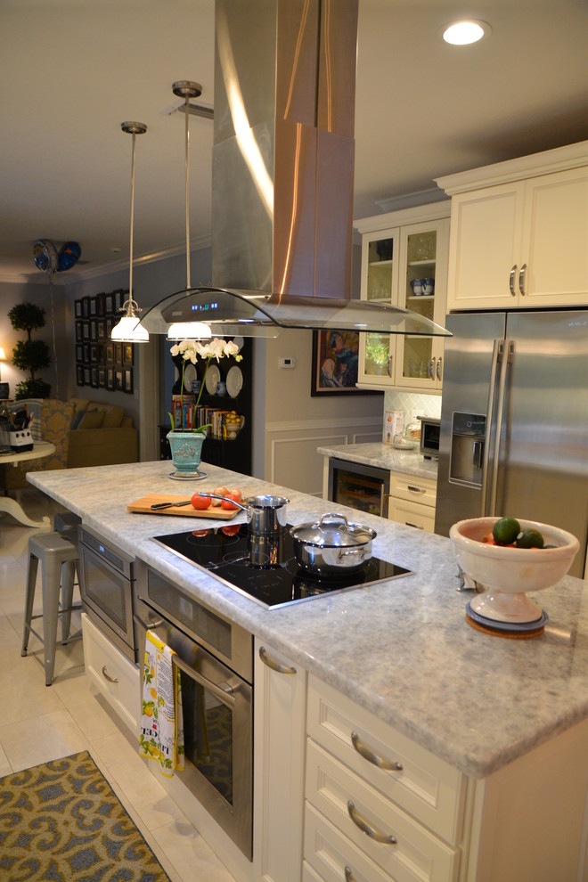 Example of a mid-sized transitional galley eat-in kitchen design in Miami with an undermount sink, shaker cabinets, white cabinets, quartzite countertops, white backsplash, stainless steel appliances, an island and gray countertops