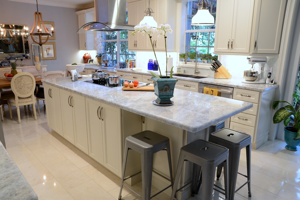 Inspiration for a mid-sized transitional galley eat-in kitchen remodel in Miami with an undermount sink, shaker cabinets, white cabinets, quartzite countertops, white backsplash, stainless steel appliances, an island and gray countertops