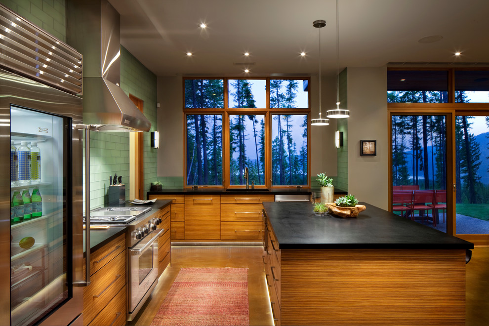 Esempio di una grande cucina contemporanea con lavello sottopiano, ante lisce, ante in legno scuro, paraspruzzi verde, paraspruzzi con piastrelle di vetro, elettrodomestici in acciaio inossidabile e pavimento in cemento